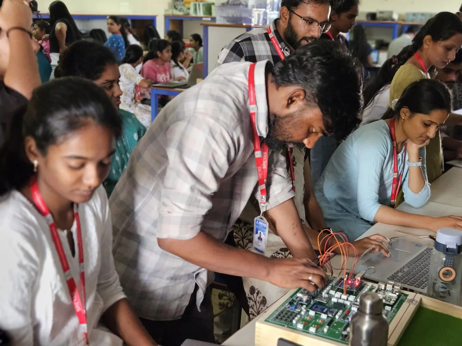 A trainer helping students wire an IoT trainer kit