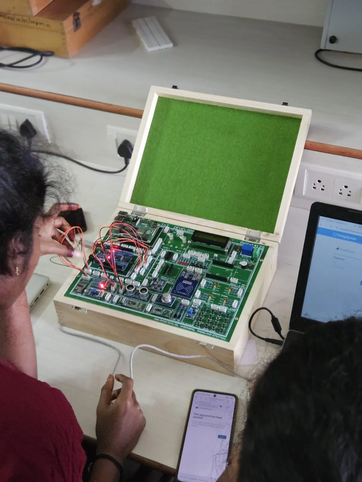 Close-up of an IoT trainer kit being used with a laptop and a phone