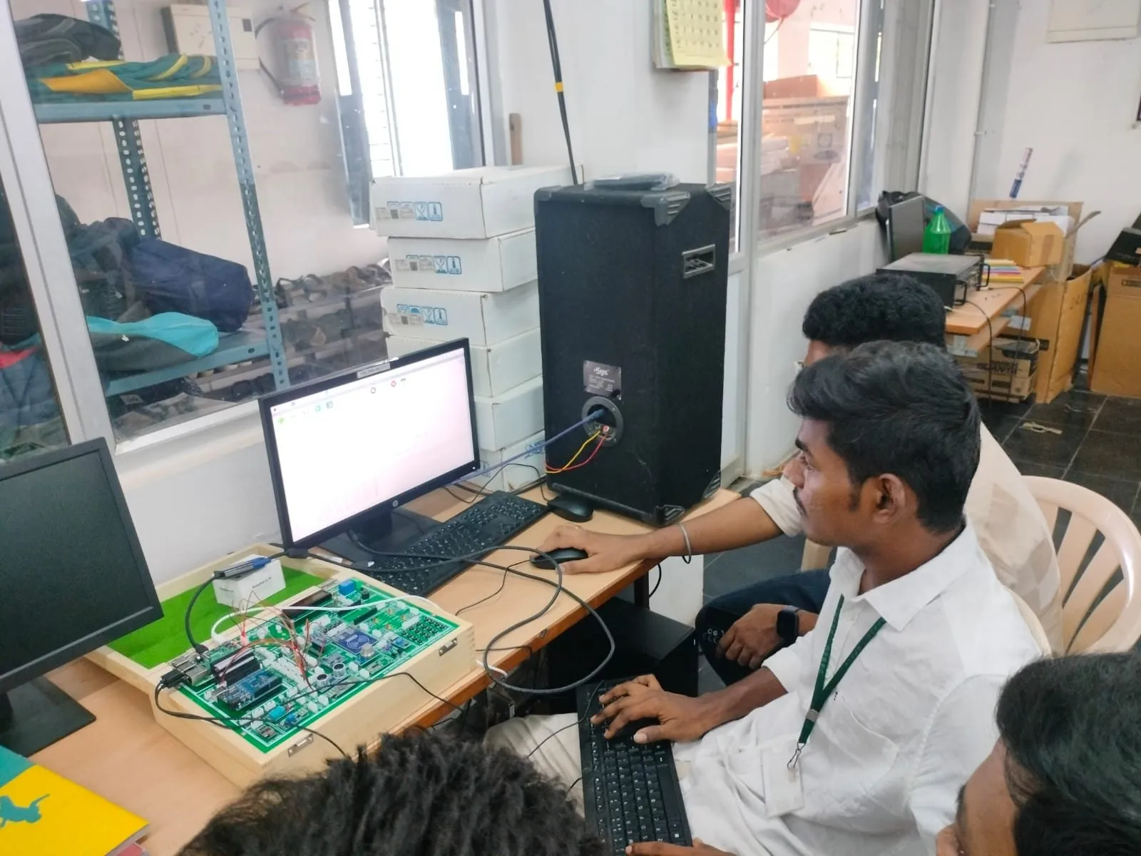 A student programming an IoT trainer kit at a computer