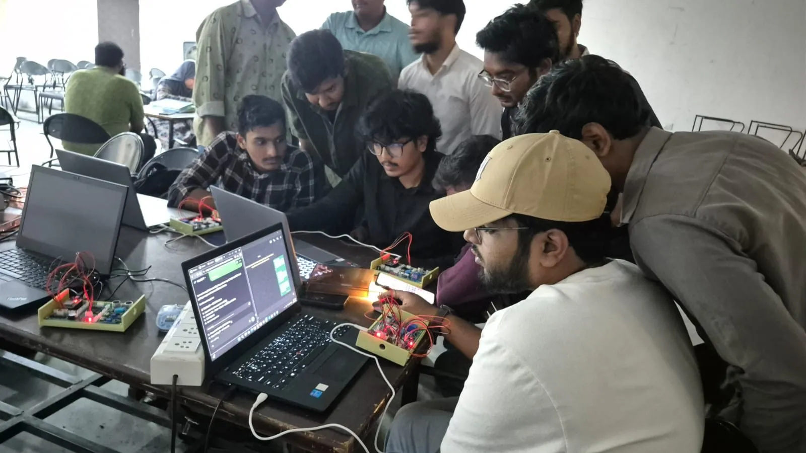 Students building and testing an IoT circuit connected to a laptop