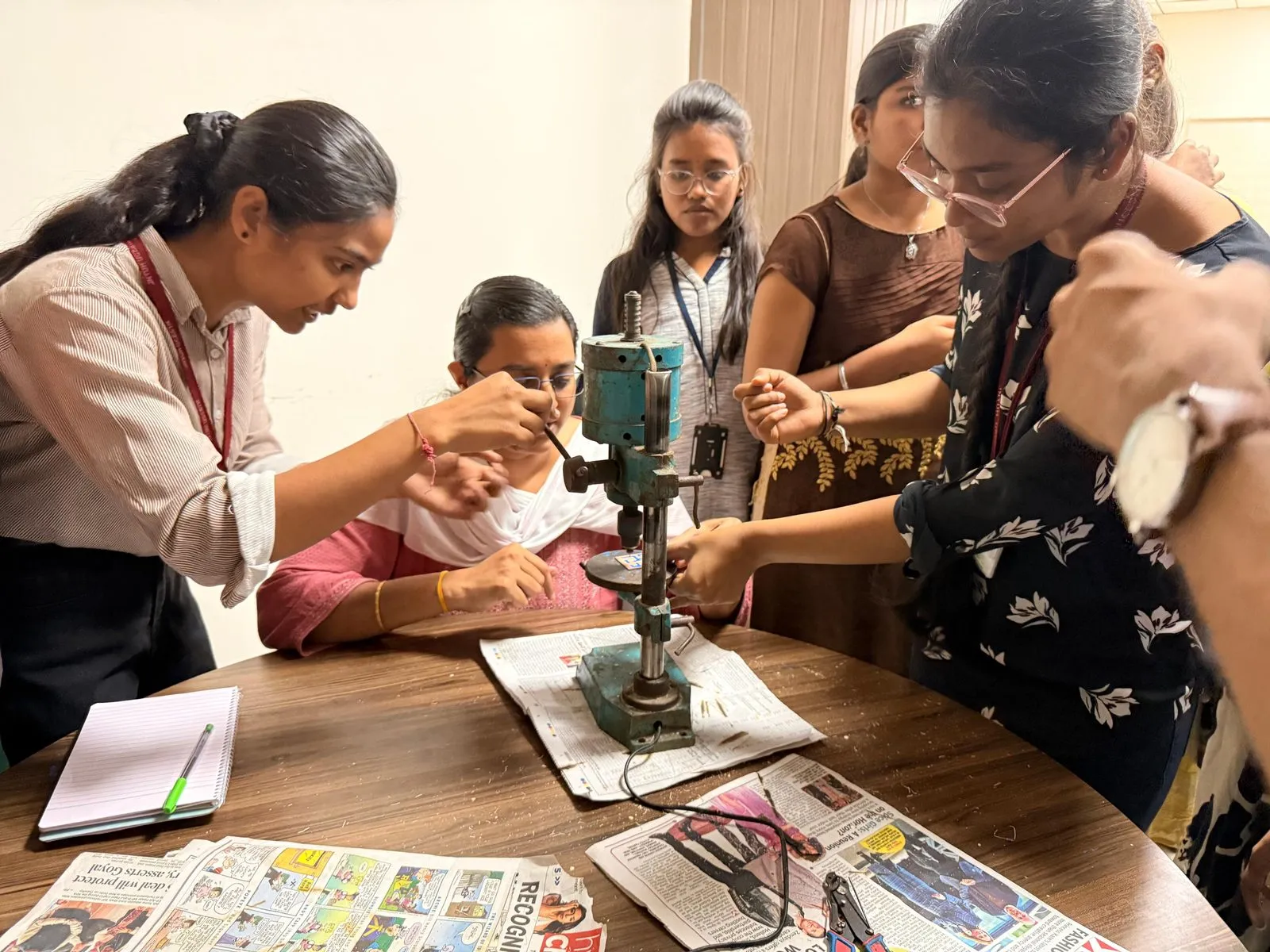 Students drilling a PCB together during the workshop