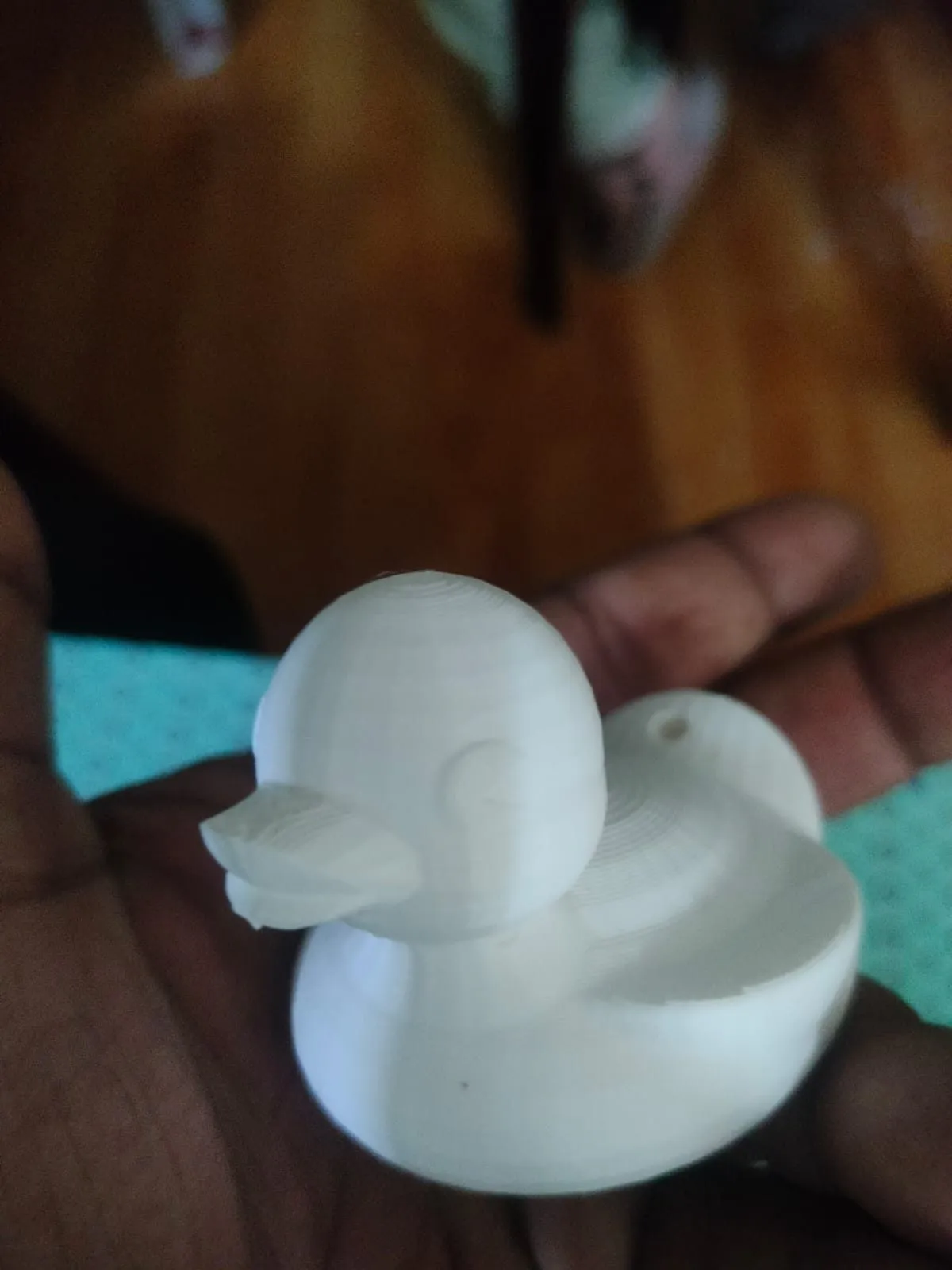 A white 3D-printed duck held in a hand