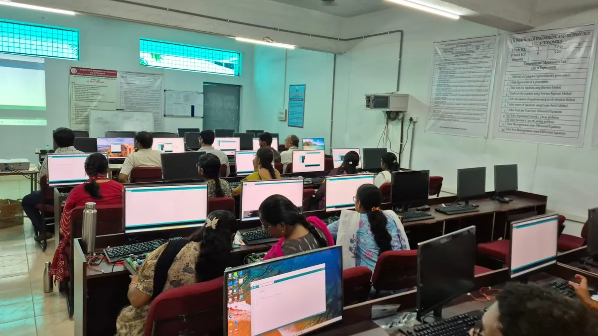Faculty working at computers in a training lab during a session