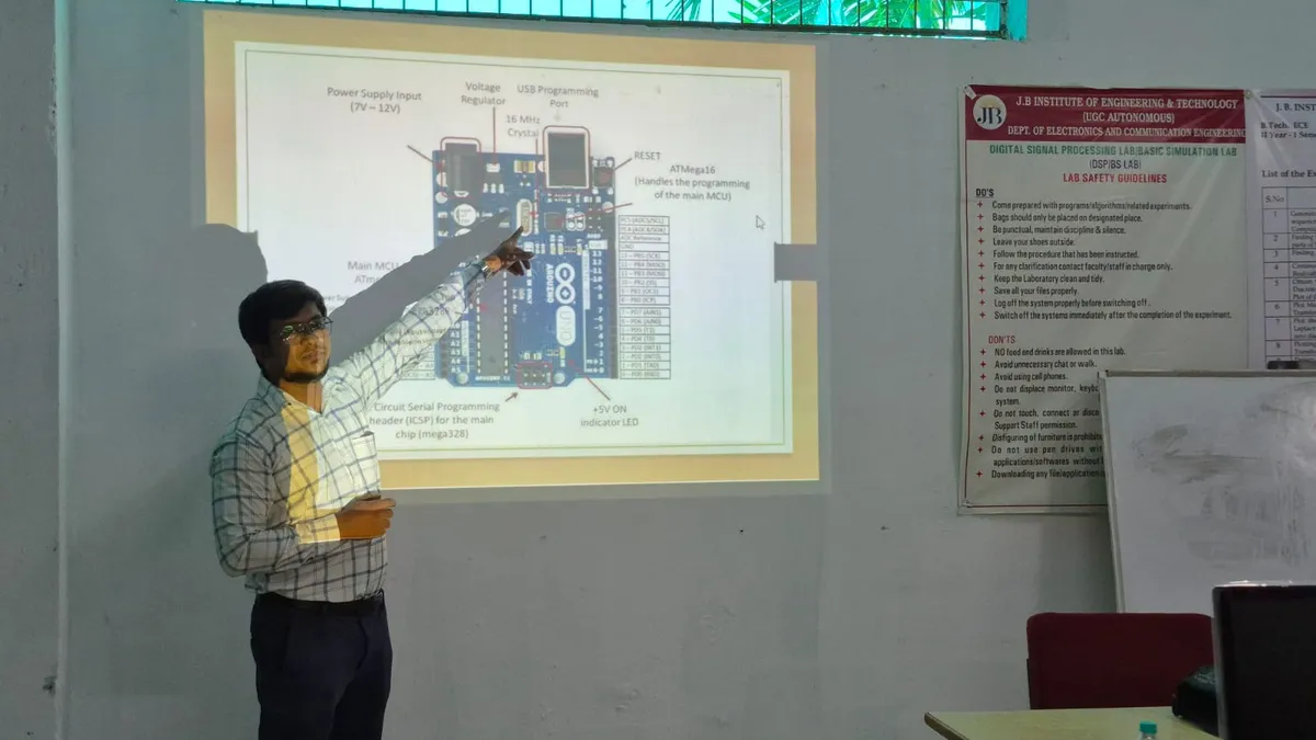 A trainer explaining an Arduino board diagram on a projector screen