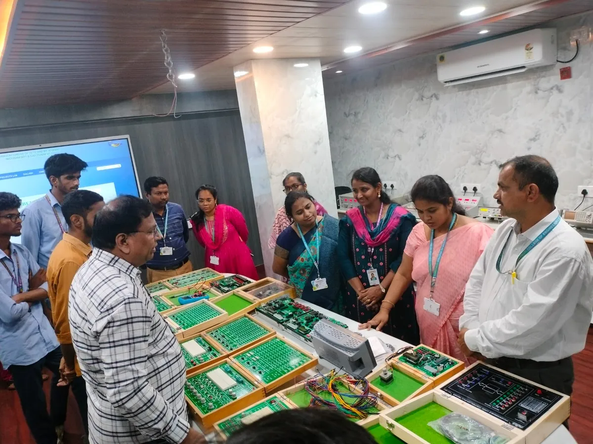 Faculty gathered around trainer kits during a hands-on session