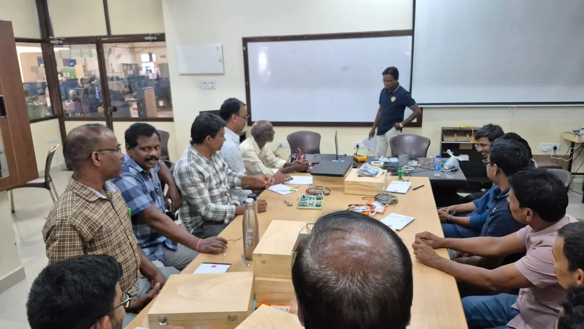 Faculty seated around a table with trainer kits during a workshop session